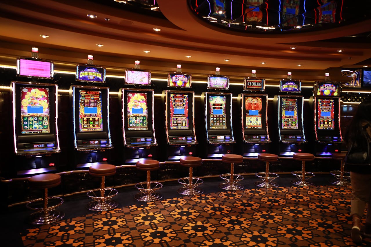 A row of luxury slot machines in a casino interior with plush stools, perfect for gaming enthusiasts.